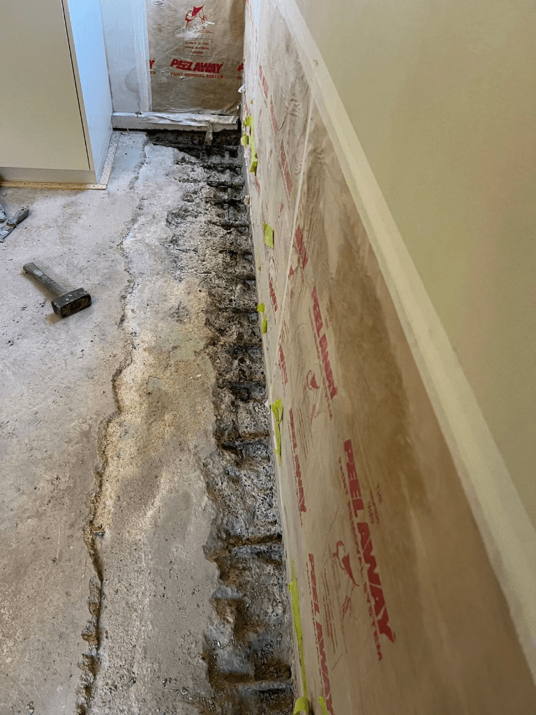 Concrete opened to expose water damage before waterproofing