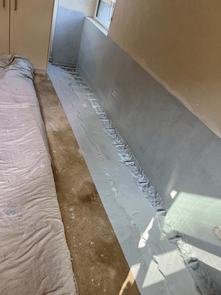 Waterproofing membrane applied along the wall and floor junction
